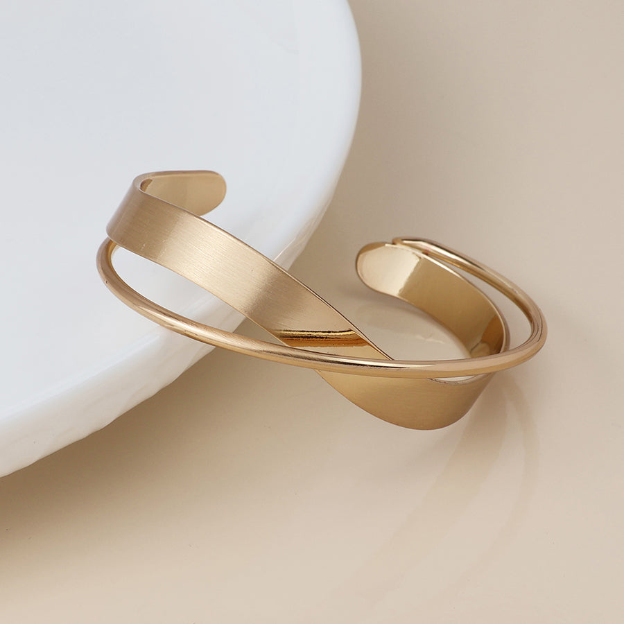 Golden brushed and smooth twist bangle
