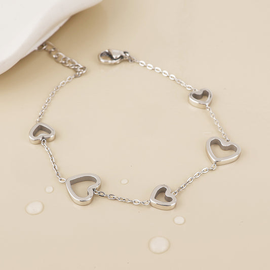 Cupid stainless steel platinum plated open hearts station bracelet